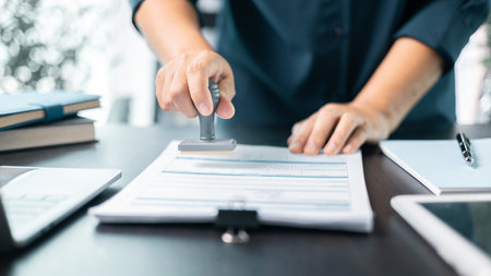 Banking officer stamped the document to approve the loan, finalizing contract and solidifying the finance agreement, fundamental concept in business transactions. approve, loan, stamp, business.の写真素材
