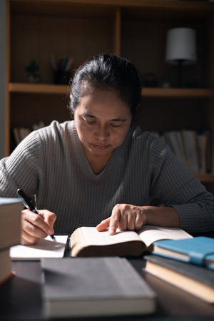 Woman with Bible in her hand, faith in God strengthened by holy words of book, found solace and inspiration through prayer in her Christian religion. bible, woman, book, religion, christian, holy.の写真素材