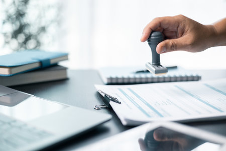 Banking officer stamped the document to approve the loan, finalizing contract and solidifying the finance agreement, fundamental concept in business transactions. approve, loan, stamp, business.の写真素材