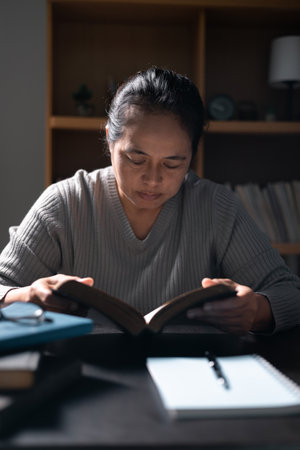 Woman with Bible in her hand, faith in God strengthened by holy words of book, found solace and inspiration through prayer in her Christian religion. bible, woman, book, religion, christian, holy.の写真素材