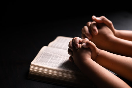 Bible in hand, a Christian prays with faith and hope, seeking guidance from God and the teachings of Jesus Christ in the gospel. hand, bible, faith, gospel, christian, god, prayer, religion, hope.の写真素材