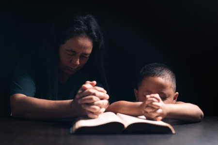 A mother teaches her child about Jesus Christ and the Christian faith, reading the Bible together and nurturing his belief in God. child, jesus christ, bible, christian, mother, person, faith, boy.の写真素材