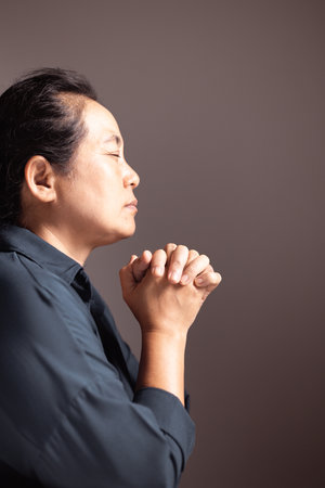 A young woman, hands clasped in prayer, meditates on her faith, seeking guidance from God and Jesus Christ in a moment of deep religious devotion. person, woman, faith, pray, prayer, hand, religion.の写真素材