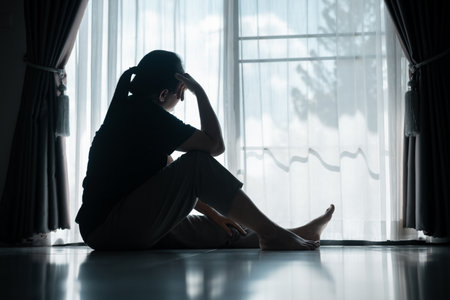 young woman sat alone, feeling weight of anxiety, stress, and depression, her sadness echoing struggles many people face in silence. anxiety, stress, depression, woman, person, sad, adult, alone.の写真素材