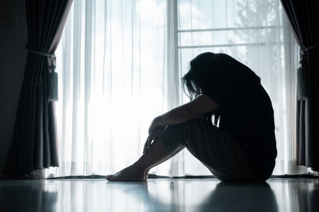 young woman sat alone, feeling weight of anxiety, stress, and depression, her sadness echoing struggles many people face in silence. anxiety, stress, depression, woman, person, sad, adult, alone.の写真素材