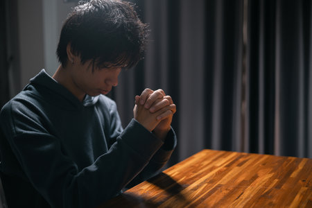 Person raised their hand in prayer at the church, embodying their Christian faith and belief in God, seeking hope and the holy presence of Christ through their devout religion. jesus christ, pray.の写真素材