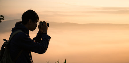 At sunrise, holiday maker embraced adventurous lifestyle of hiking through fog-covered mountains,...