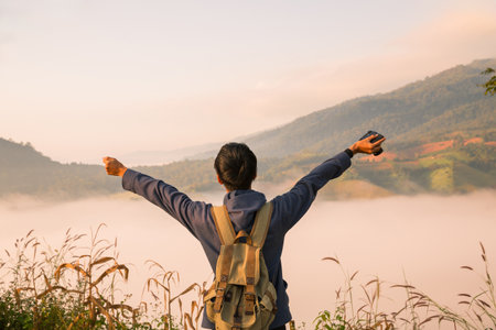 At sunrise, holiday maker embraced adventurous lifestyle of hiking through fog-covered mountains, with a backpack full of essentials and deep appreciation for beauty of nature. travel, sunrise, fog.の写真素材