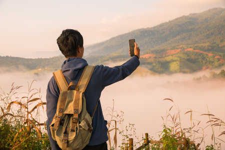At sunrise, holiday maker embraced adventurous lifestyle of hiking through fog-covered mountains,...