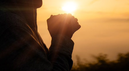 Woman in silhouette, worship in prayer at sunrise with sun rising in summer sky, embracing her faith amidst beauty of nature. worship, sunrise, woman, silhouette, sky, sun, nature, summer, prayer.の写真素材