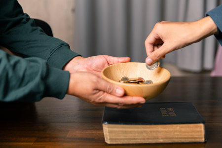 He decided to donate portion of his earnings as tithe, giving money and coins as contribution to support financial needs of community. beg, quest, request, desire, need, problem, share, charitableの写真素材