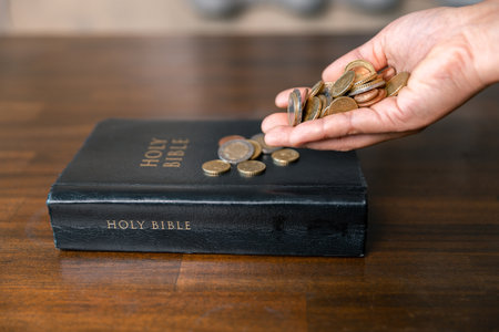 He decided to donate portion of his earnings as tithe, giving money and coins as contribution to support financial needs of community. beg, quest, request, desire, need, problem, share, charitableの写真素材