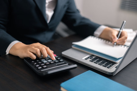 Finance bank tax expense accounting budget money hand use calculator Financial calculate accountant close up calculator with graph chart write office desk Business expense analysis savingの写真素材