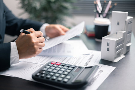 Finance bank tax expense accounting budget money businessman home for Business expense analysis saving use Financial calculate accountant close up calculator with graph chart hand write office deskの写真素材