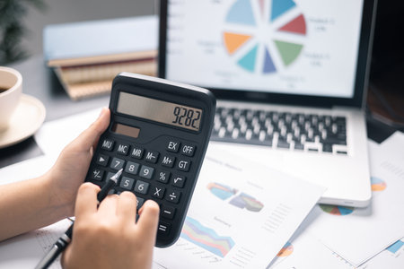 Finance bank tax expense accounting budget money businessman hand use calculator Financial calculate accountant close up calculator with graph chart write office desk Business expense analysis savingの写真素材
