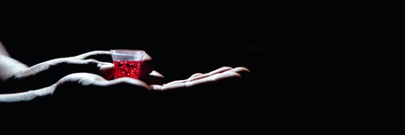 Close up of hands holding a small container, possibly related to a religious ceremony or practice.の写真素材