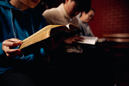 Close up christians hands pray to God with spiritual faith on holy bible in catholic church religion...