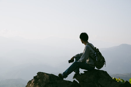 Man traveler with camera backpack hiking outdoor travel lifestyle and adventure concept. cap backpack and join of tourist for green mountain tour, beauty of nature and expansive sky people of tourismの写真素材