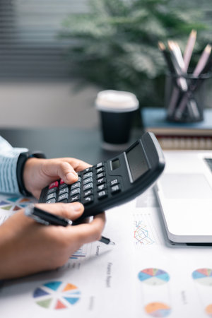 Finance bank tax expense accounting budget money businessman hand use calculator Financial calculate accountant close up calculator with graph chart write office desk Business expense analysis savingの写真素材
