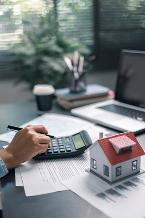 Finance bank tax expense accounting budget money businessman home for Business expense analysis saving use Financial calculate accountant close up calculator with graph chart hand write office deskの写真素材