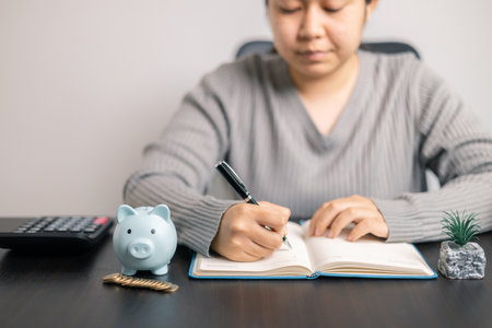 Finance bank tax expense accounting budget money businessman hand use calculator Financial calculate accountant close up calculator with graph chart write office desk Business expense analysis savingの写真素材