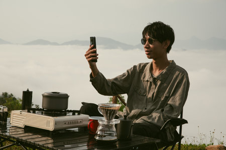Young business man working computer on peak hill. Hiker online shopping on laptop at sunset, sunrise...