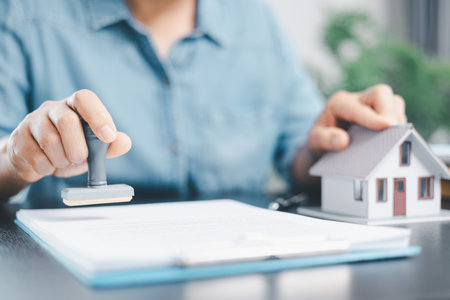 Businesswoman hand stamp approve on financial business approval document paper. Man hand accept permit contract agreement. Broker manager sign contract bank guarantee approved stamp application formの写真素材