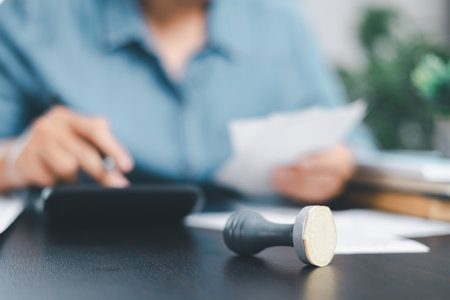 Businessman hands stamp approve on financial business approval document paper. Man hand accepted permit contract agreement. Broker manager sign contract bank guarantee approved stamp application formの写真素材