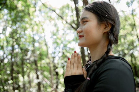 Grateful woman having HOPE praying to God. Spiritual girl smiling to sky. Happy female being thankful. Spiritual girl praying with hope. Positive Asian young woman feeling hope and faith looking up.の写真素材