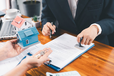 Bank approve loan to buy home concept. Real estate agent talked about terms of home purchase agreement, asked customer to sign documents to make contract legally. approved mortgage application form.の写真素材