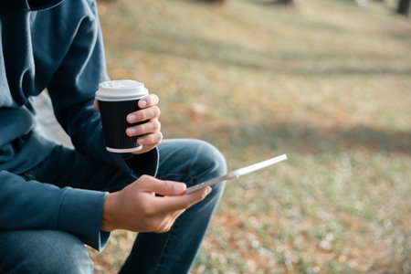 Remote work technology online close up communication smart phone laptop telephone digital travel brown nature sunlight camp beverage morning sit drink coffee tent orange outlying concept background.の写真素材