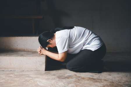 Female kneeling down praying for worship God at home. Christians pray to jesus christ for calmness....