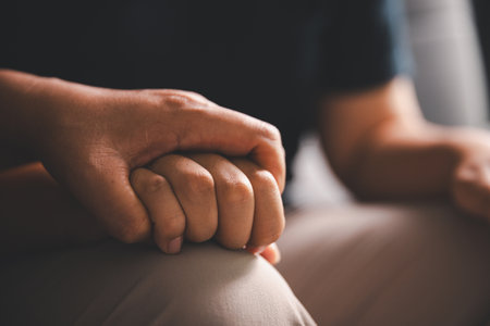 Hope and trust with crisis concept. Closeup, love and holding hands for support, comfort and care with grief, loss and empathy. people and family with compassion, sympathy and healing with bonding.の写真素材
