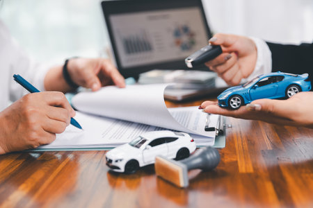 à¸ºBusinessman approval stamper stamp on paper business contract. car loan money approved. Dealer or manager gives car to customer sign car purchase document with insurance, contract to buy car legal.の写真素材