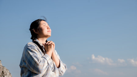 Grateful woman having HOPE praying to God. Spiritual girl smiling to sky. Happy female being thankful. Spiritual girl praying with hope. Positive Asian young woman feeling hope and faith looking up.の写真素材