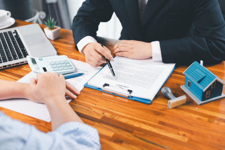 Bank approve loan to buy home concept. Real estate agent talked about terms of home purchase agreement, asked customer to sign documents to make contract legally. approved mortgage application form.の写真素材