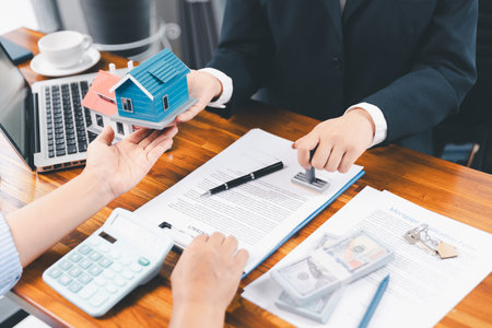 Bank approve loan to buy home concept. Real estate agent talked about terms of home purchase agreement, asked customer to sign documents to make contract legally. approved mortgage application form.の写真素材