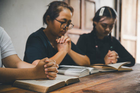 Praying religion, worship and group of people pray to God, Family, holding hands and prayer in home for love, support and faith or hope in house. holy spirit or Jesus for peace or spiritual praise.の写真素材