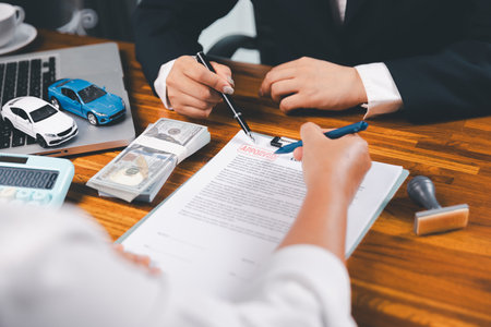 à¸ºBusinessman approval stamper stamp on paper business contract. car loan money approved. Dealer or manager gives car to customer sign car purchase document with insurance, contract to buy car legal.の写真素材