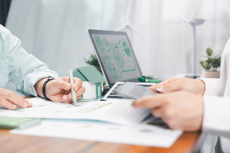 Business people working on sustainable innovation project. renewable energy concept. Teamwork Meeting, partner on model building company office technology, based green businesses and global warming.の写真素材