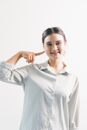 Asian woman rejoicing, looking happy, champion, fist pump gesture, standing over white background. young woman had happy, positive expression on her face, highlighted by bright smile.の写真素材