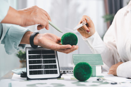 Business people working on sustainable innovation project. renewable energy concept. Teamwork Meeting, partner on model building company office technology, based green businesses and global warming.の写真素材