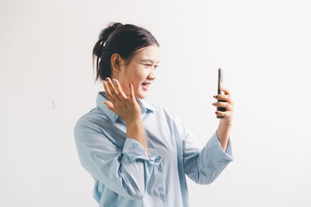 Asian woman rejoicing, looking happy, champion, fist pump gesture, standing over white background. young woman had happy, positive expression on her face, highlighted by bright smile.の写真素材