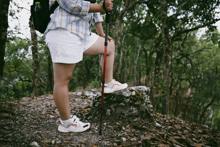Hiking action on mountain grass trail path. Close up of female hiker shoe. adventurous lifestyle of hiker and backpack to travel and trek mountain, enjoy every walk and hike part of thrilling journeyの写真素材