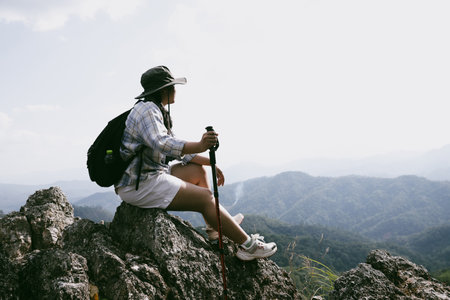 Woman hiker on top of mountain. Hiker with arms up on top of mountain successful young woman enjoying triumph. traveler exploring world. Hikers with backpacks relaxing. Sport and success concept.の写真素材