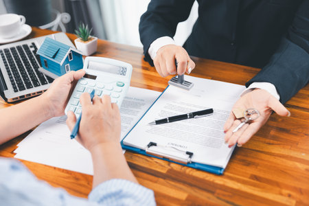 Bank approve loan to buy home concept. Real estate agent talked about terms of home purchase agreement, asked customer to sign documents to make contract legally. approved mortgage application form.の写真素材