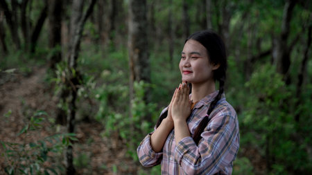 Grateful woman having HOPE praying to God. Spiritual girl smiling to sky. Happy female being thankful. Spiritual girl praying with hope. Positive Asian young woman feeling hope and faith looking up.の写真素材