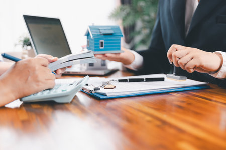 Bank approve loan to buy home concept. Real estate agent talked about terms of home purchase agreement, asked customer to sign documents to make contract legally. approved mortgage application form.の写真素材