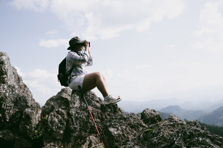 Woman hiker on top of mountain. Hiker with arms up on top of mountain successful young woman enjoying triumph. traveler exploring world. Hikers with backpacks relaxing. Sport and success concept.の写真素材