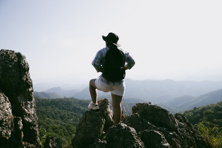 Woman hiker on top of mountain. Hiker with arms up on top of mountain successful young woman enjoying triumph. traveler exploring world. Hikers with backpacks relaxing. Sport and success concept.の写真素材